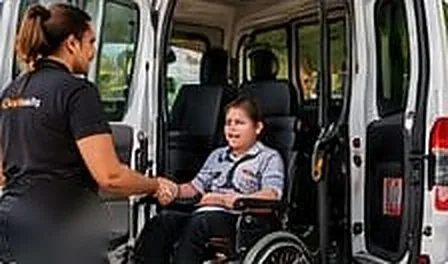 Support worker helping a young person in a wheelchair into an accessible van