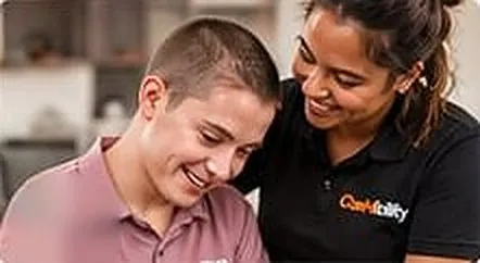 Support worker sitting with a smiling young man at home